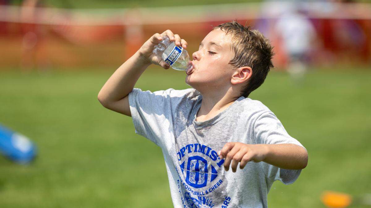 Cooper Judd, 8, finishes a bottle of water during a break at the Optimist Youth Football Kids Skills Camp at Optimist Youth Sports Complex, Saturday, July 13, 2024.