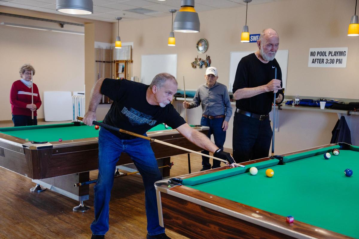 John McKinley, center, plays pool at billiards area in the Meridian Senior Center. Lisa Hansen, executive director of the center said many of the center members are grandparents who have followed children and grandchildren to the city.