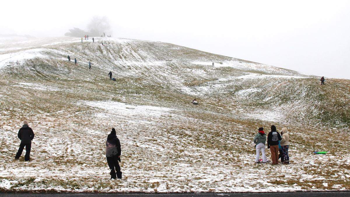 Families sled and play in the snow at the foggy Simplot Hill near the corner of Cartwright and Bogus Basin roads in Boise on New Year’s Day.