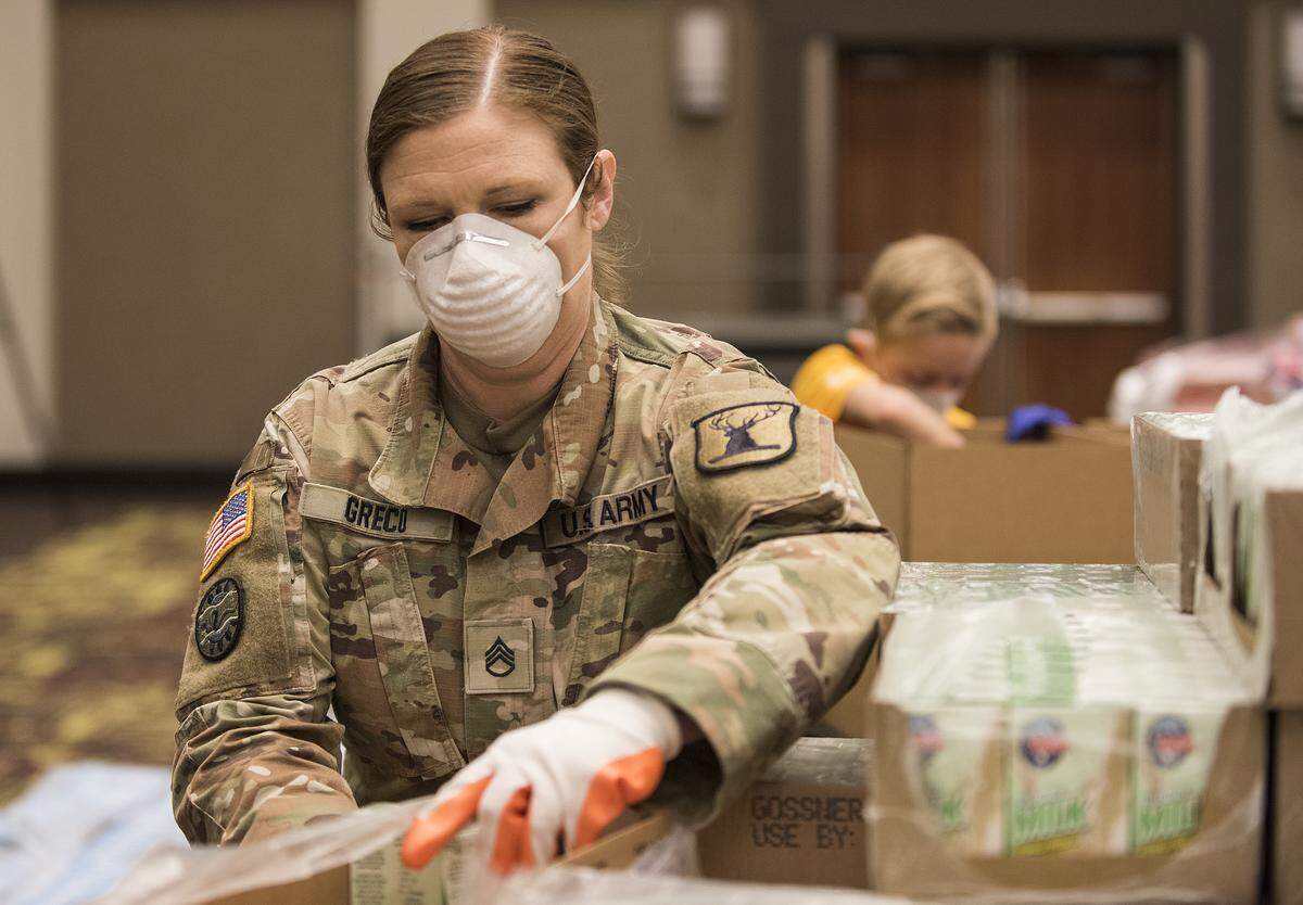 Staff Sgt. Heather Greco, of Nampa, of the Idaho National Guard helps employees of the Idaho Foodbank and volunteers from Idaho’s Dairy West at the Boise Centre to build food boxes for Idaho students in need on April 8.