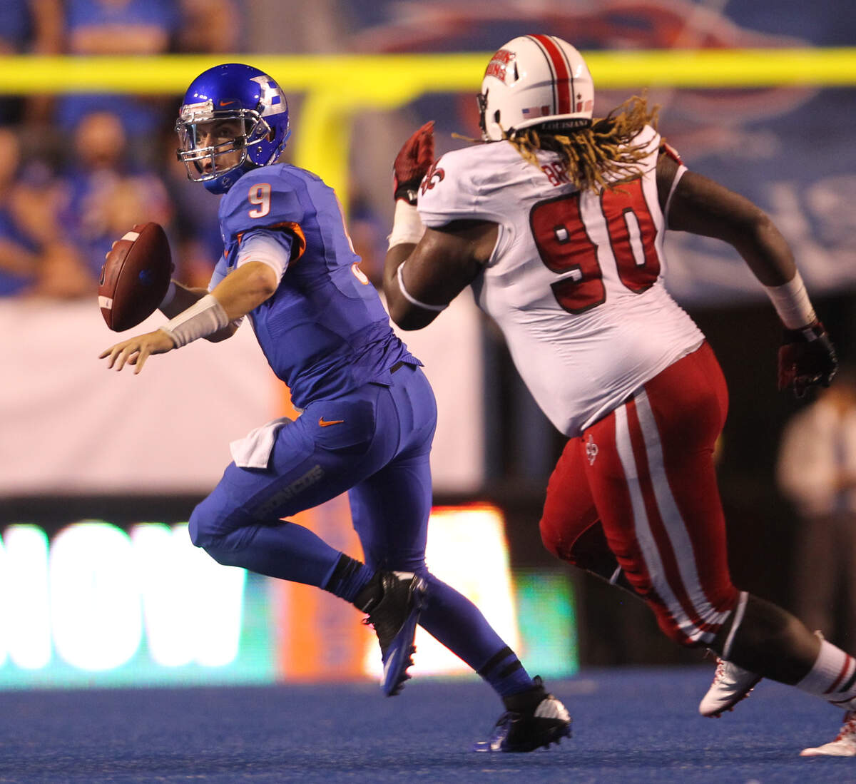Boise State quarterback Grant Hedrick scrambles away from Louisiana-Lafayette defensive tackle Jacoby Briscoe in the second half at Albertsons Stadium on Saturday September 20, 2014.