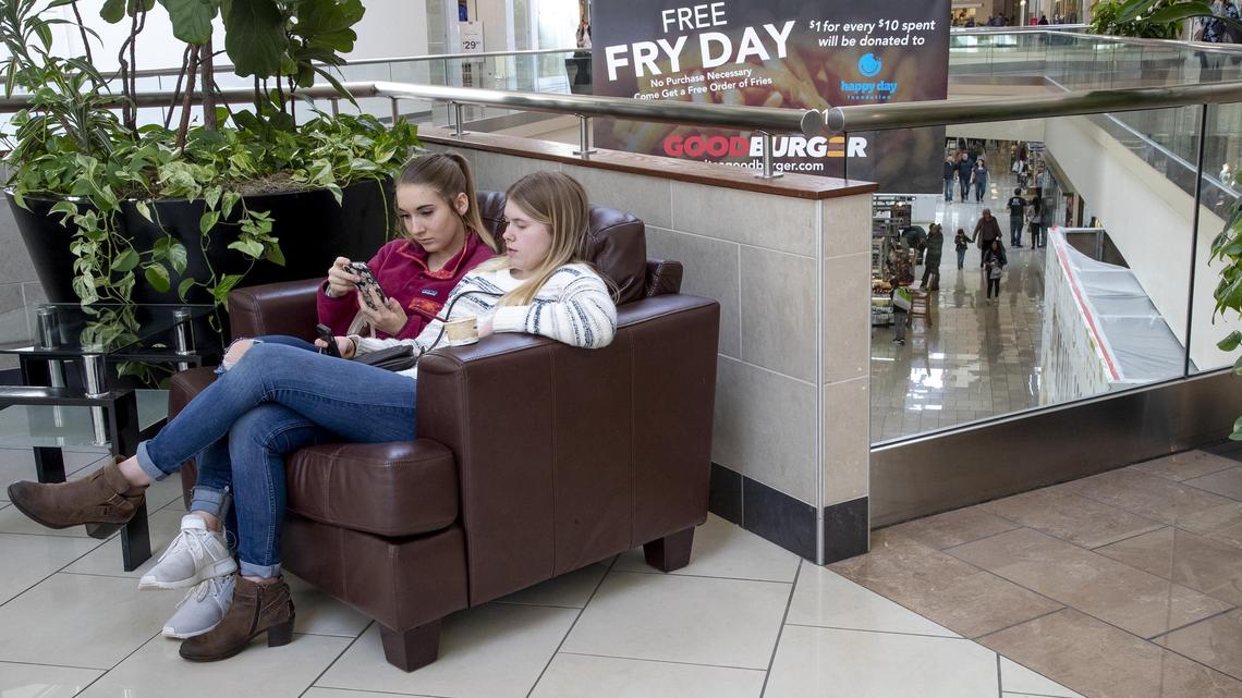 Freya Von Till, 16, and Gabby Ranney, 17, visiting from Coeur d’ Alene, share a chair at Boise Towne Square on Friday.