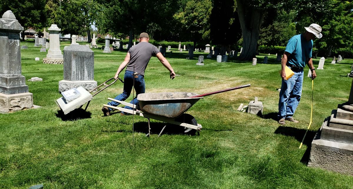 Jake Meyer, an employee with Boise Valley Monument, pulls a hand truck with the headstone for Corilla Robbins through Boise’s Pioneer Cemetery on Tuesday, while company owner Phil Fouts measures the distance from the pedestal of Robbins’ husband, Orlando “Rube” Robbins. “We don’t often do something this old, datewise, so it’s cool to see this,” Meyer said.
