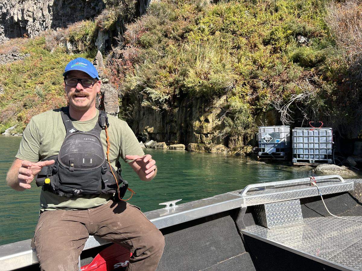 Jeremey Varley, the chief treatment engineer for the Idaho Department of Agriculture, explains on Oct. 10, 2025 how the department injected a liquid copper solution (pictured at right) into the Snake River to kill invasive quagga mussels.
