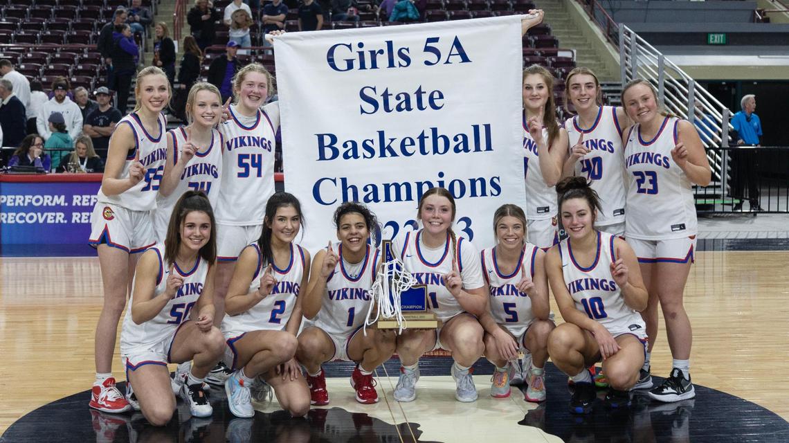 Coeur d’Alene poses with the 5A state championship trophy and banner after a 65-27 win over Rocky Mountain on Saturday.