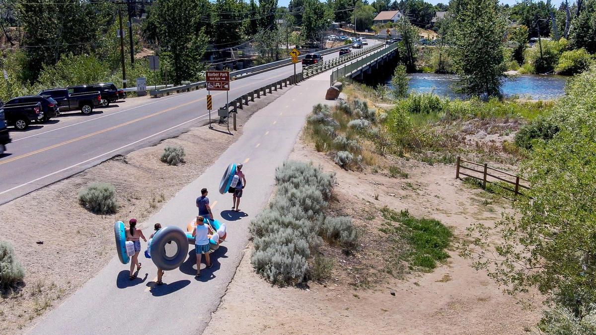 Summer floaters cross the Eckert Road Bridge in Southeast Boise. The bridge has access to Barber Park, where people can rent inner tubes and rafts to float the Boise River.