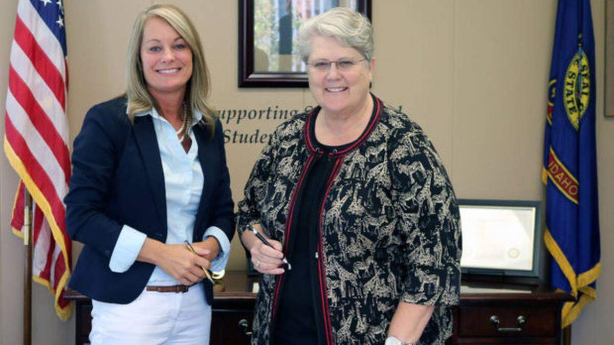 Schools chief Sherri Ybarra, left, and State Board of Education member Linda Clark pose with the consolidated state plan before submitting it to the U.S. Department of Education in 2018.