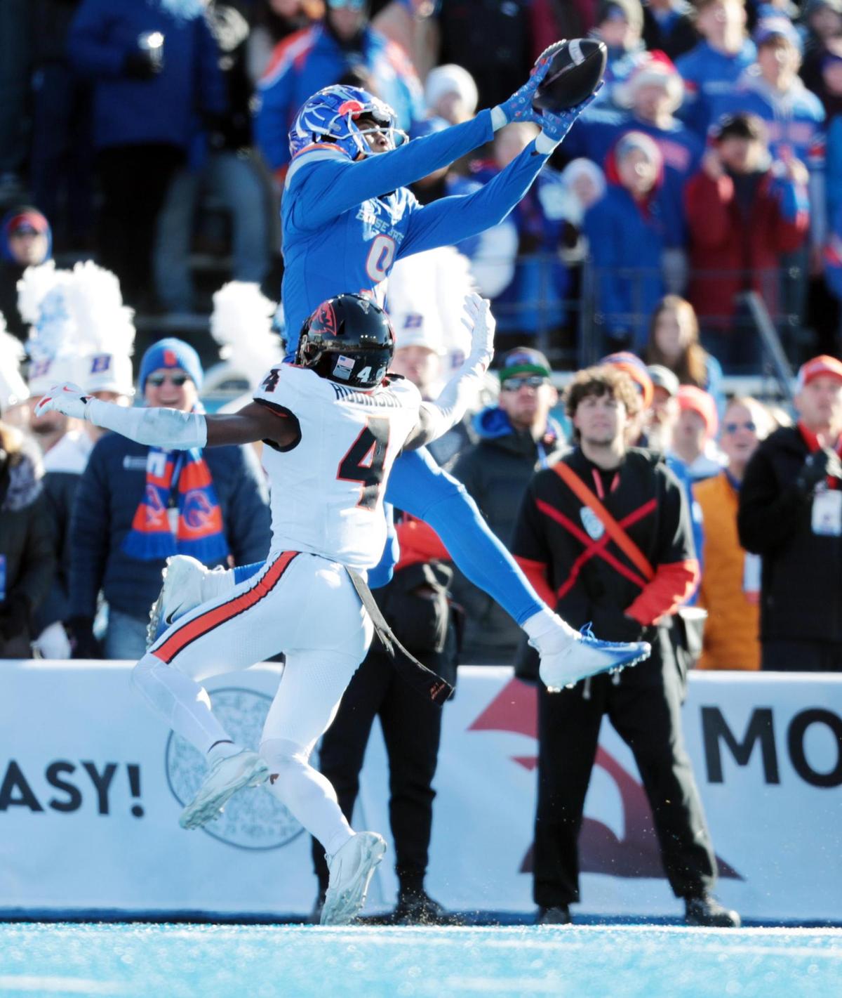 Boise State wide receiver Cameron Camper reaches for a catch while being defended by Oregon State defensive back Jaden Robinson during the first half of the game at Albertson’s Stadium.