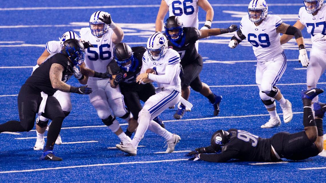 Boise State defenders Scott Matlock (99), Shane Irwin (55), and Scale Igiehon (90) bring down BYU quarterback Zach Wilson (1) during last season’s game against BYU.
