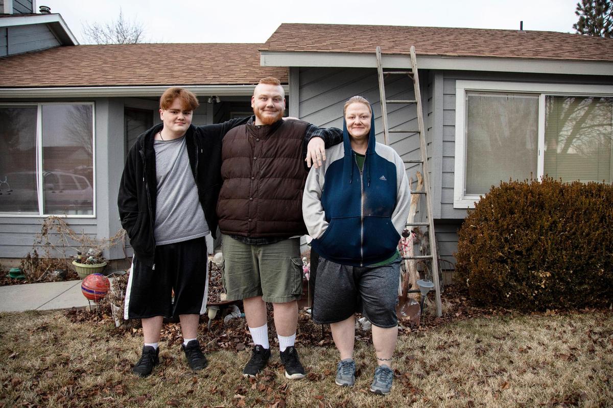 Brothers Tayden Thorne, 15, left, and Tyler Thorne, 22, stand with their mother Teresa Thorne outside of the Boise home they have rented for eight years through the Section 8 voucher program. They have a few weeks left to find a new home that will accept their voucher as their current landlord needs to use the house for a family member who is also struggling with housing.