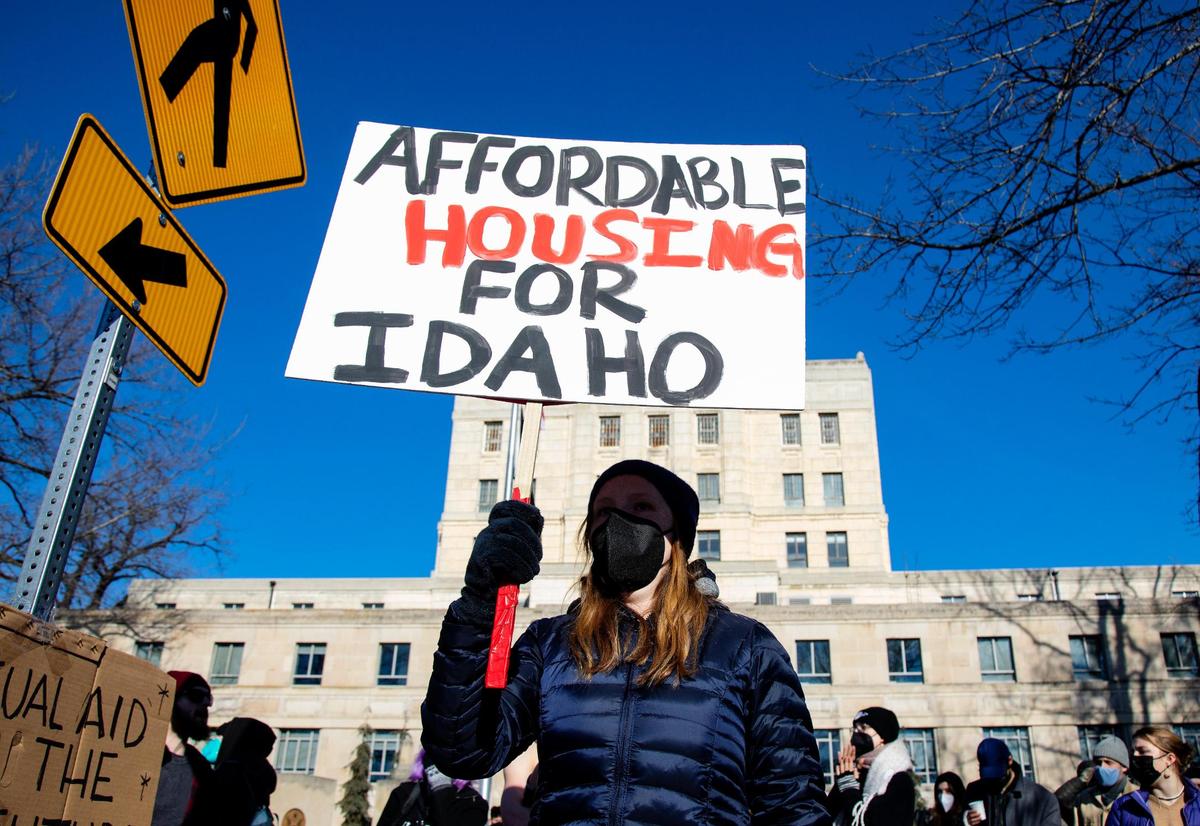 Supporters of the homeless community, as well as unhoused individuals themselves, stand with signs in reaction to a counter protest by the Idaho Liberty Dogs on Saturday, Jan. 29, 2022, outside the former Ada County Courthouse building in downtown Boise.