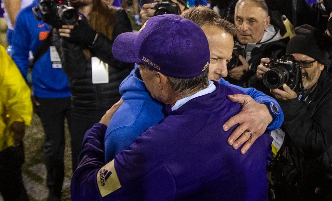 Boise State football coach Bryan Harsin gives Washington coach Chris Petersen, front, a hug at midfield after a 38-7 Washington win in the Las Vegas Bowl on Saturday at Sam Boyd Stadium in Las Vegas.