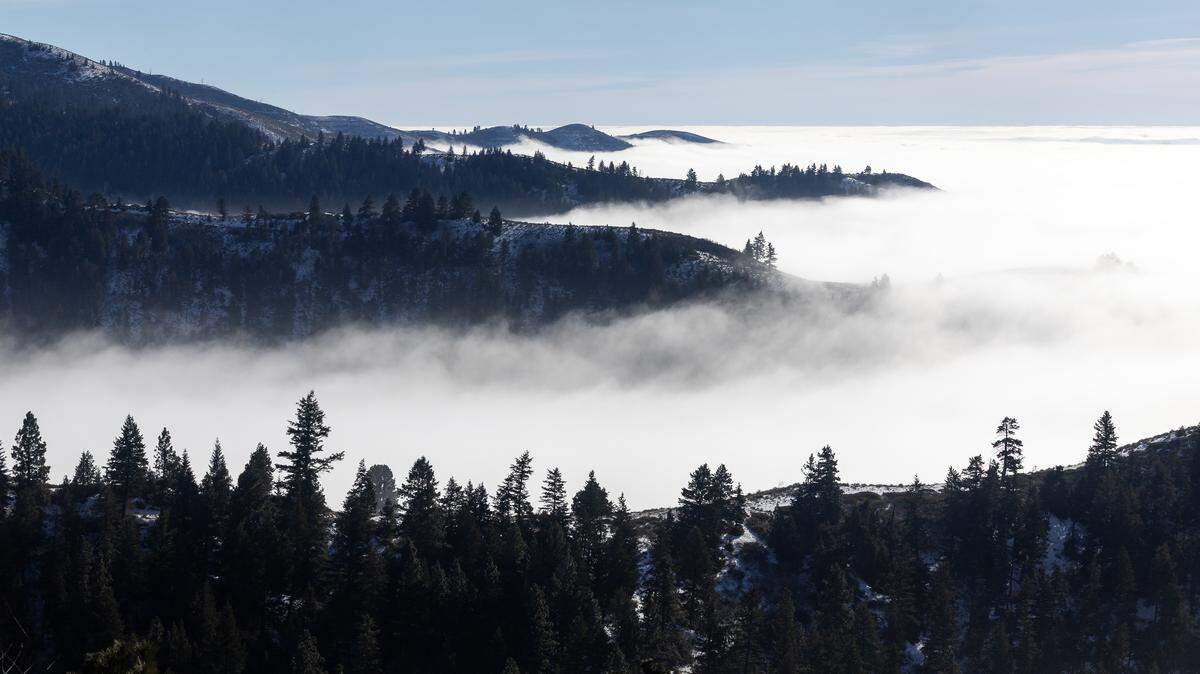 Clouds and fog settle into the valleys below the headwaters of Upper Dry Creek off Bogus Basin Road, Tuesday, Jan. 20, 2026. An inversion over the Boise area is preventing cold air from rising, causing cool, moist air to become trapped near the surface.