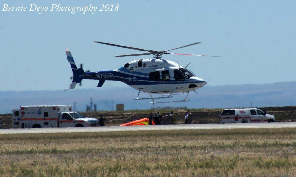 Emergency responders tend to hang glider pilot Dan Buchanan after his glider crashed Saturday afternoon during the Gunfighter Skies air show at Mountain Home Air Force Base. Buchanan was taken to a local hospital, where he died. Sunday's show will be dedicated to him.