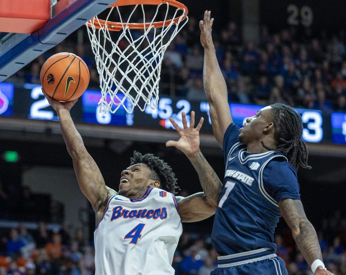 Boise State guard Dylan Andrews draws a foul and scores a bucket defended by Utah State guard Kolby King at ExtraMile Arena in Boise, Saturday, Jan. 10, 2026.