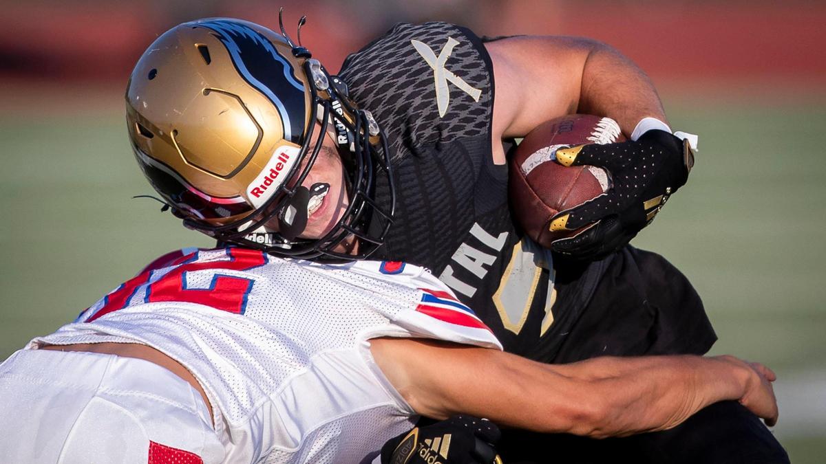 Capital running back Jacob Olson takes a hit from Nampa senior Cody Rowley at Dona Larsen Park earlier this fall.