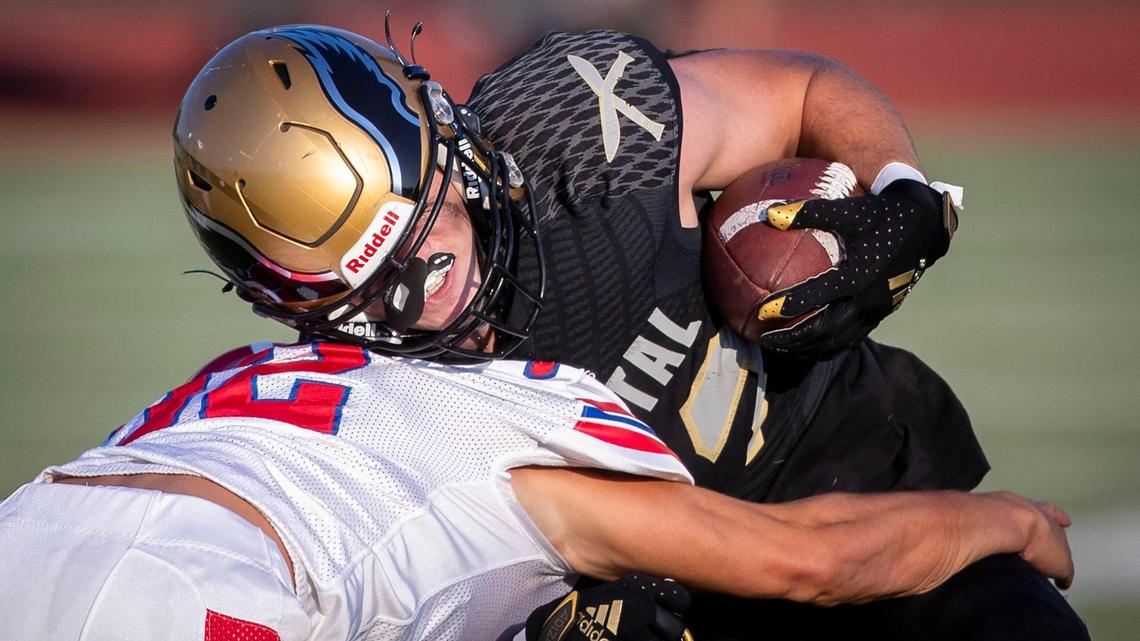 Capital running back Jacob Olson lowers his shoulder into Nampa senior Cody Rowley on Thursday at Dona Larsen Park in Boise.
