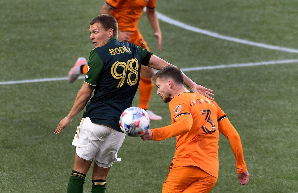 PORTLAND, OREGON - APRIL 24: Blake Bodily #98 of Portland Timbers and Adam Lundqvist #3 of Houston Dynamo go after a ball during the first half of the match at Providence Park on April 24, 2021 in Portland, Oregon. The Timbers won 2-1. (Photo by Steve Dykes/Getty Images)