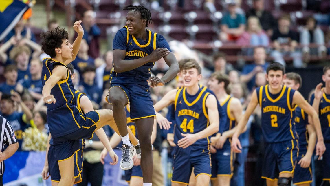 Meridian seniors Austin Ramos, left, and Ladu Kaden celebrate at the buzzer after defeating Madison 71-67 in the first round of the 5A boys basketball state tournament Thursday at the Ford Idaho Center in Nampa.