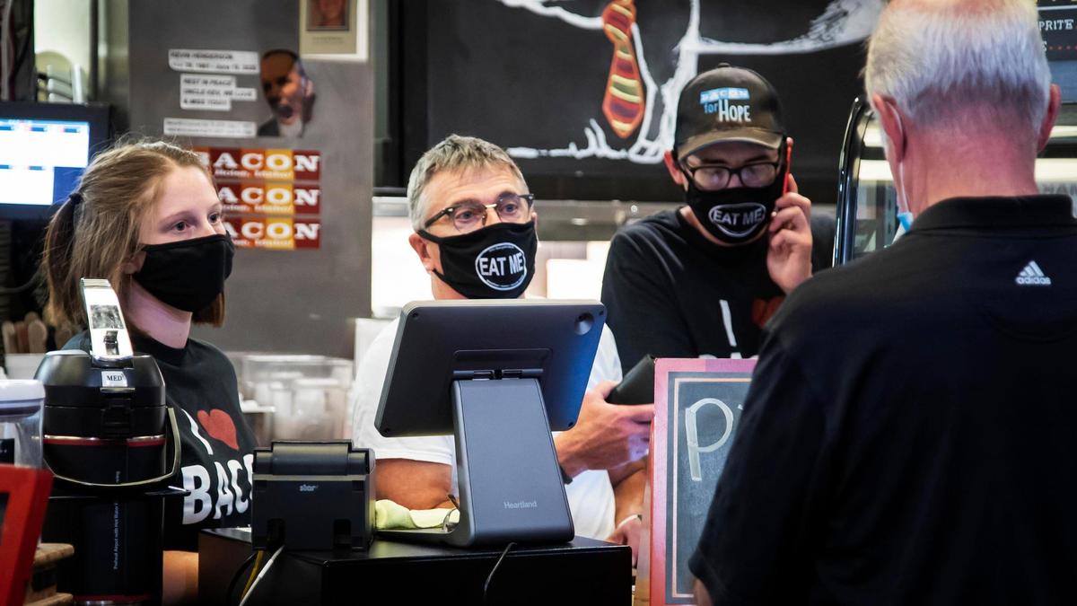 Bacon co-owner John Berryhill, center, helps a customer in this 2020 photo.