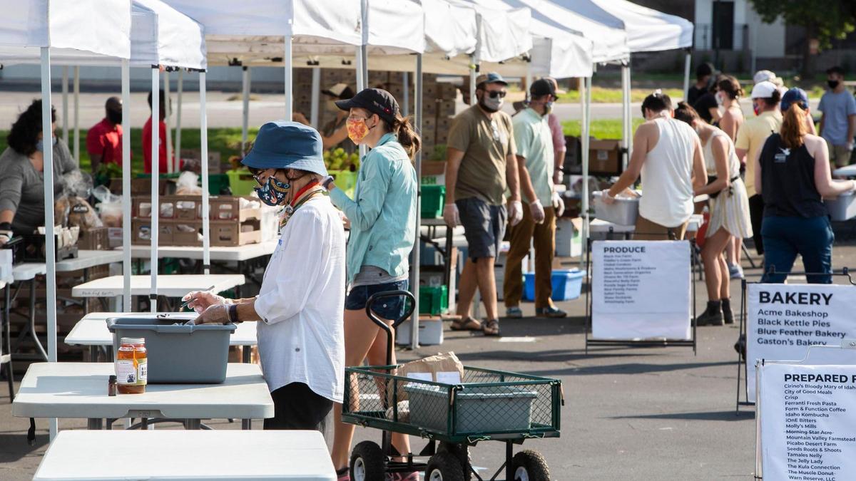 Abigail, a masked volunteer at Boise Farmer’s Market, prepares preordered lists Saturday, Sept. 5, 2020, for patrons before they arrive at the market’s drive through service during the coronavirus pandemic.