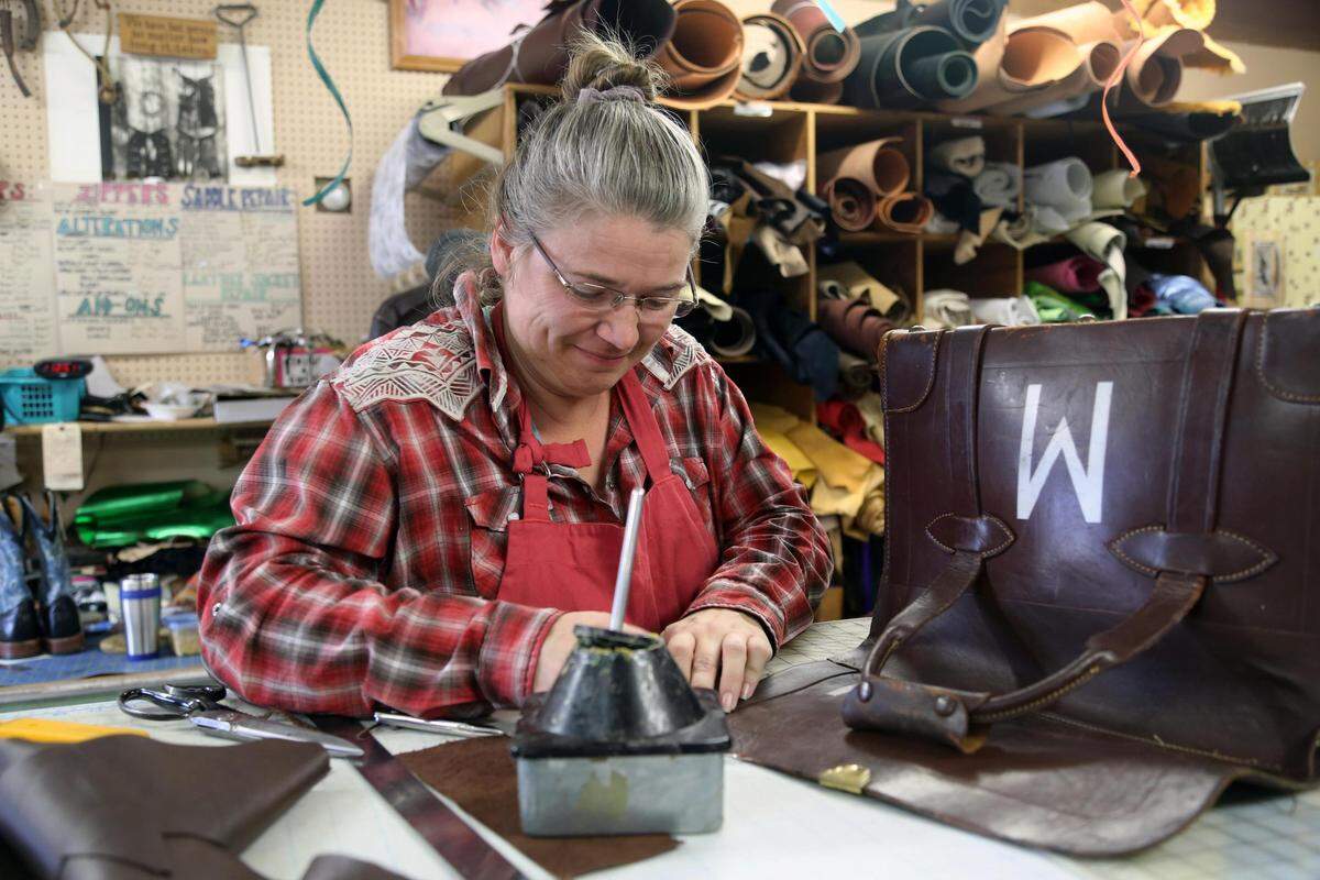 Kathleen Mautz works on glueing the seams of a leather eyeglass bag. “We really don’t want this place to close,” said Mautz, who took over the leatherworking at Hap Tallman’s in August.