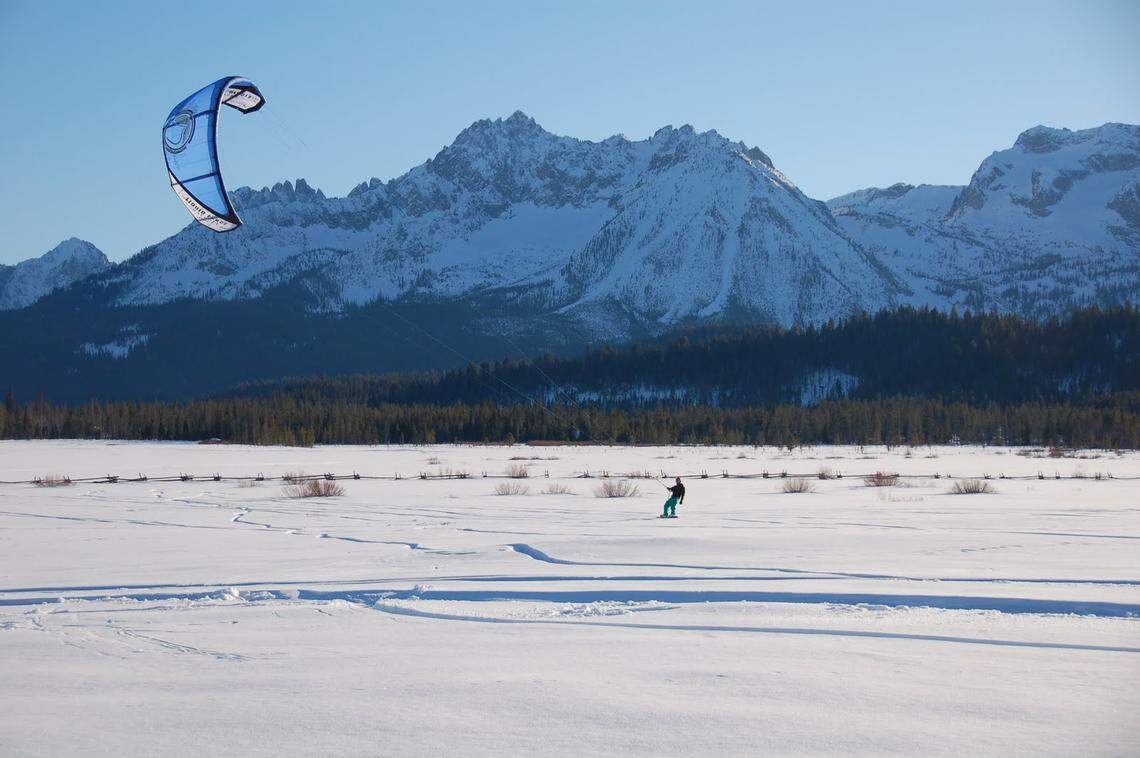 Greg Halbart, of Savannah, Georgia, snowkites near Stanley, Idaho, with the Sawtooth Mountains behind him.
