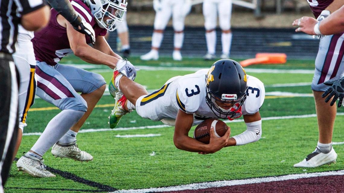 Meridian High quarterback Malakai Martinez dives into the end zone for the Warriors’ second touchdown Friday at Centennial High.