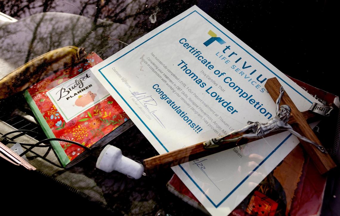 Thomas Lowder keeps a budget planner, a depiction of Jesus and his new certificate of completion from substance abuse treatment on the dash of the SUV.
