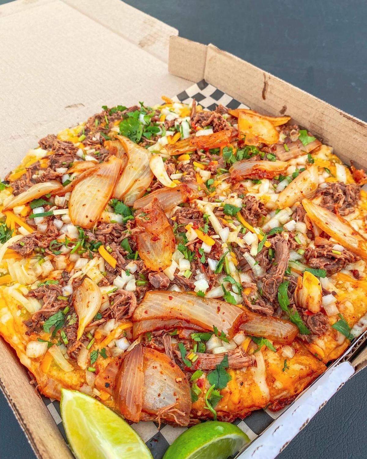 Dip a slice. PizzaBirria comes with two 16-ounce cups of consomé.