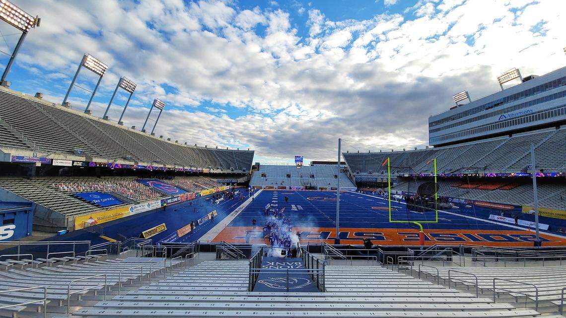 Boise State football players run onto The Blue for their 2020 season opener Saturday at Albertsons Stadium. There were no fans, just cardboard cutouts in the stands in the lower level.