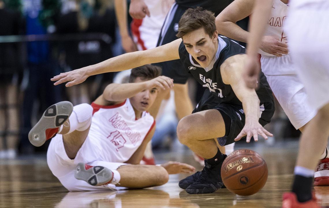 Eagle freshman Donovan Jones dives for a loose ball against Madison in the first round of the 5A boys basketball state tournament Thursday at the Ford Idaho Center in Nampa.
