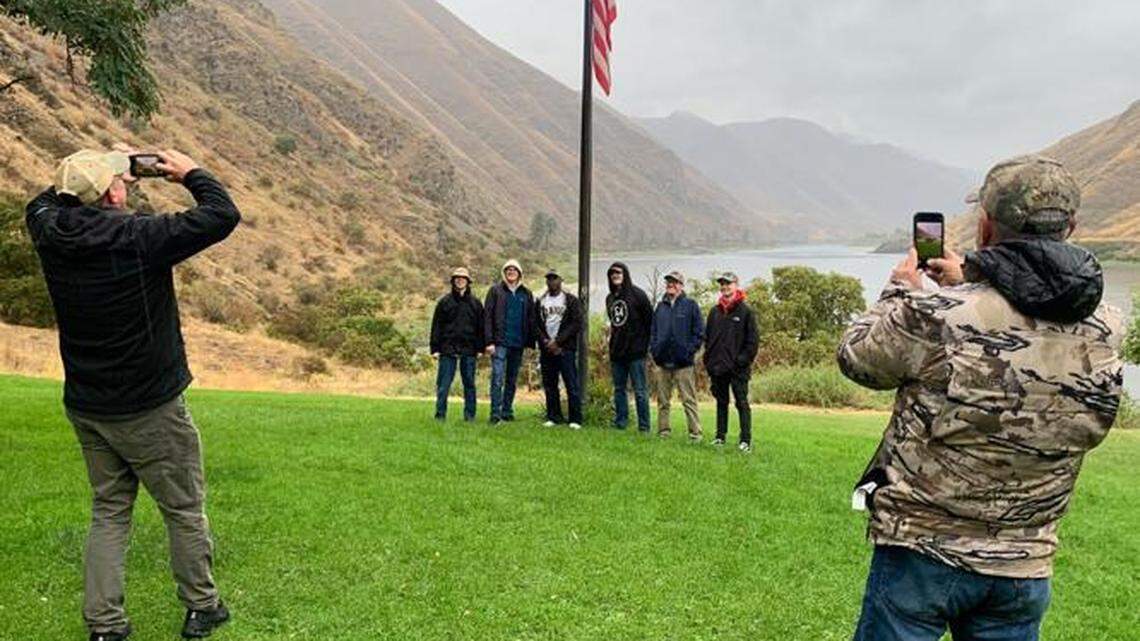 USS Idaho submariners pose for photos near the American flag at Cache Creek Ranch in Hells Canyon on Thursday. The Navy sailors spent the past week exploring the Gem State.