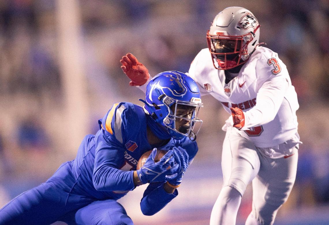 Boise State wide receiver Billy Bowens catches a long pass against defense by New Mexico safety Patrick Peek during the second half of the game at Albertsons Stadium. Boise State defeated New Mexico 37-0 at the half Saturday November, 20, 2021.