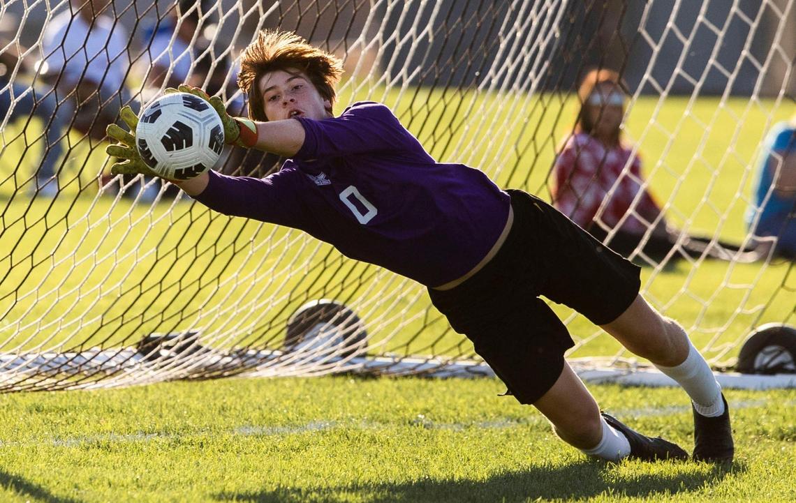 Bishop Kelly goalkeeper Justin McGrew makes a diving save during the 4A District Three boys soccer championship last fall.