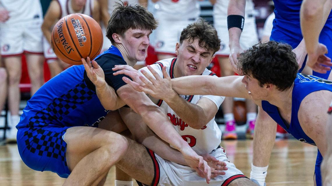 Owyhee guard Cam Downie battles for control of the ball with Timberline’s Carson Huegerich, left, and Bryce Heinz in the semifinals of the 6A boys basketball state tournament Friday.