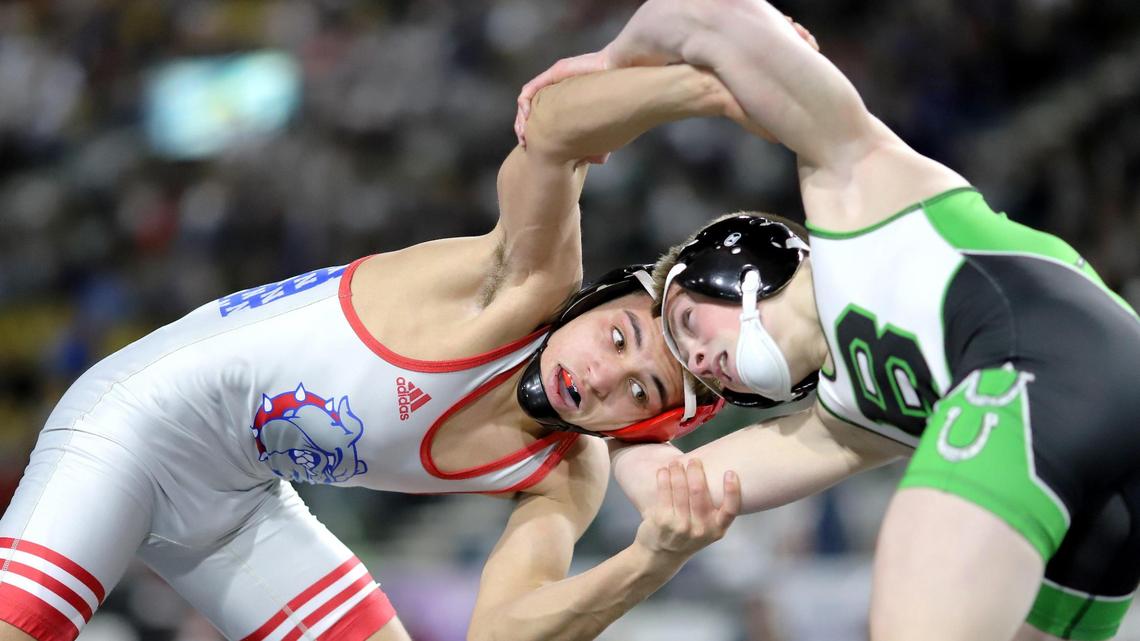 Nampa junior Dedrick Navarro, left, spars with Blackfoot’s Mack Mauger during the 4A 106-pound state finals Saturday at Holt Arena in Pocatello. Mauger won the bout 3-1.
