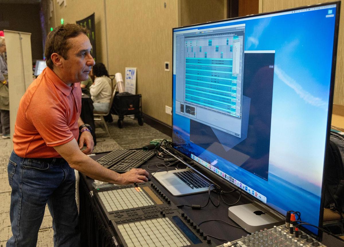 David Reyes sets up audio for attendees to listen to at the Experience Immersive Audio exhibit at Hackfort on Thursday. The exhibit featured immersive audio applications from Dolby Atmos and Sound Particles, two programs that are used to make soundscapes for movies.