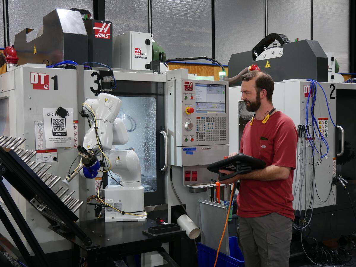 At Holstery, a tool belt manufacturer in Moscow, Leif Colson prepares a robotic arm to load aluminum stock into a milling machine. President Trump’s tariffs have increased Holstery CEO Josh Hartung’s desire to bring more manufacturing processes in-house, but they also pose challenges.