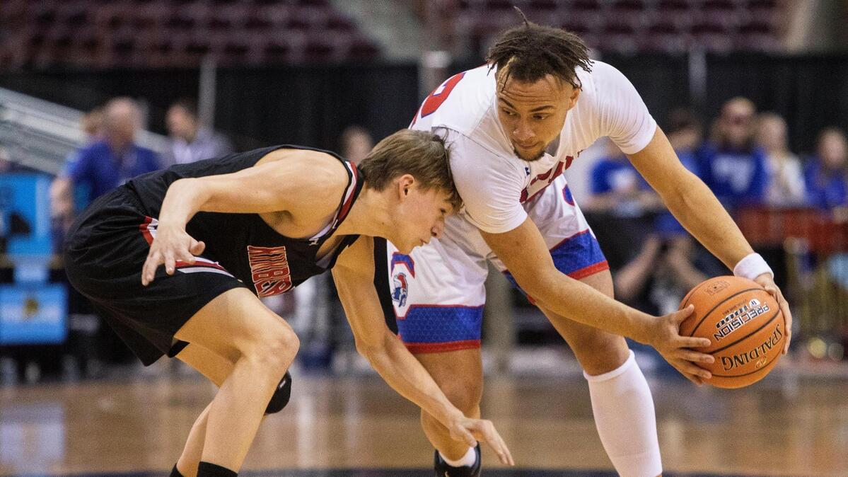 McCall-Donnelly’s DJ Green holds off the defense of Kimberly’s Dylan Hollist in the 3A boys basketball state championship game on Saturday. Kimberly won 40-22.