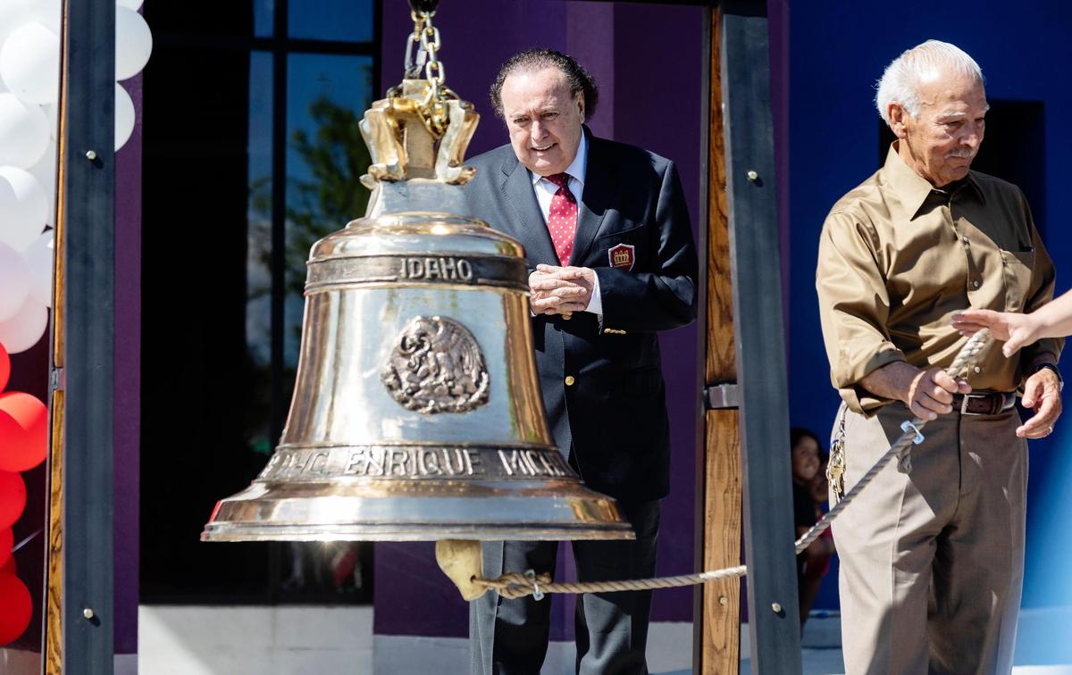 The owner of the international corporation, Dulces de La Rosa, Enrique Michel Velasco, watches as others ring the bell he donated to the Hispanic Cultural Center of Idaho.
