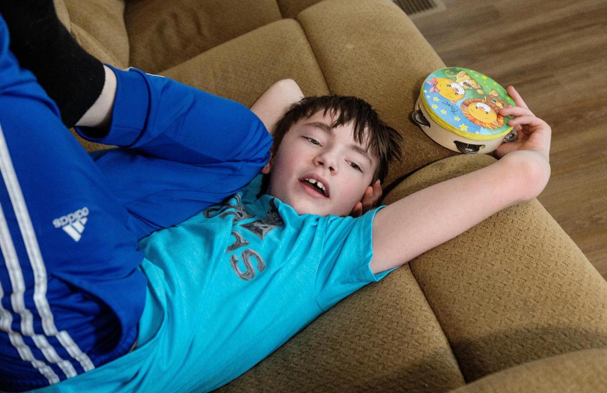 Katie Mengel’s son Kaydyn plays in the living room. Each time the family has moved, Kaydyn has had to adjust to a new school.