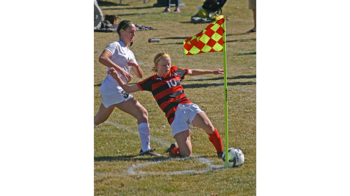 Boise sophomore Kendra McDaniel slides trying to keep the ball in play in front of Borah senior Mya McArthur during Thursday’s 5A state tournament opener at the Idaho Falls Soccer Complex.