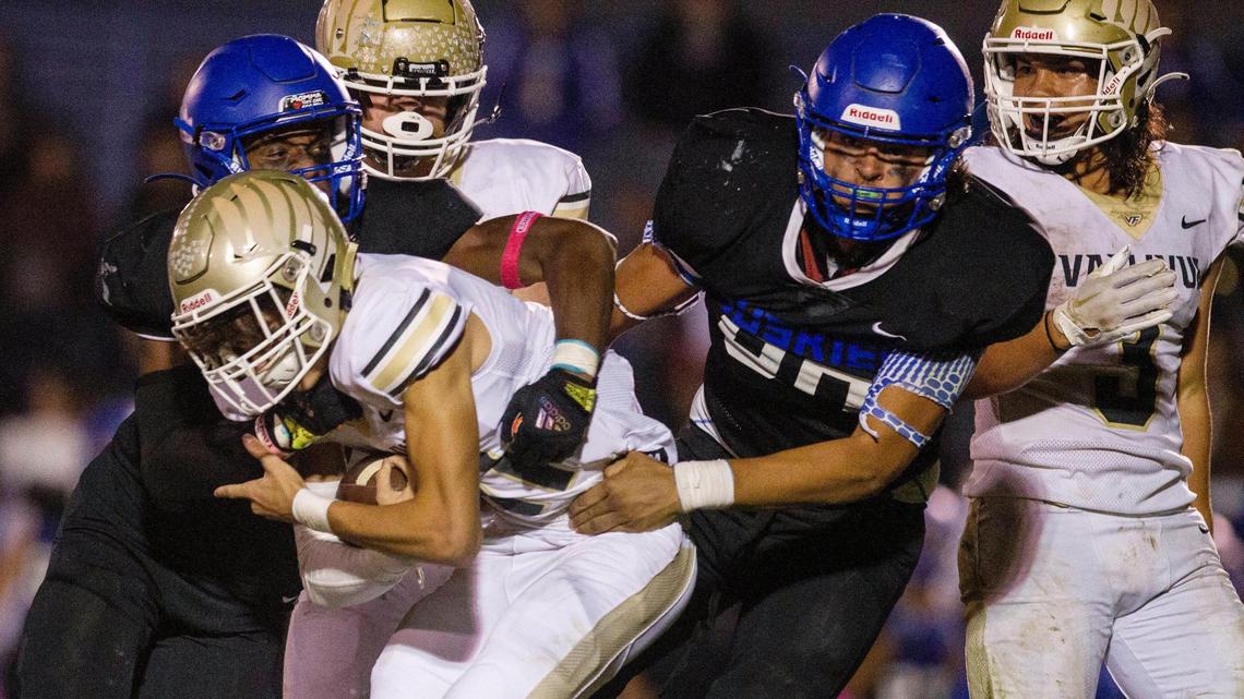 Emmett defenders Lucas Briscoe, left, and Cristian Sanchez, right, combine to drop Vallivue quarterback Isaac Moore on Friday. Emmett rallied for a 21-20 win to clinch a 4A state playoff berth.