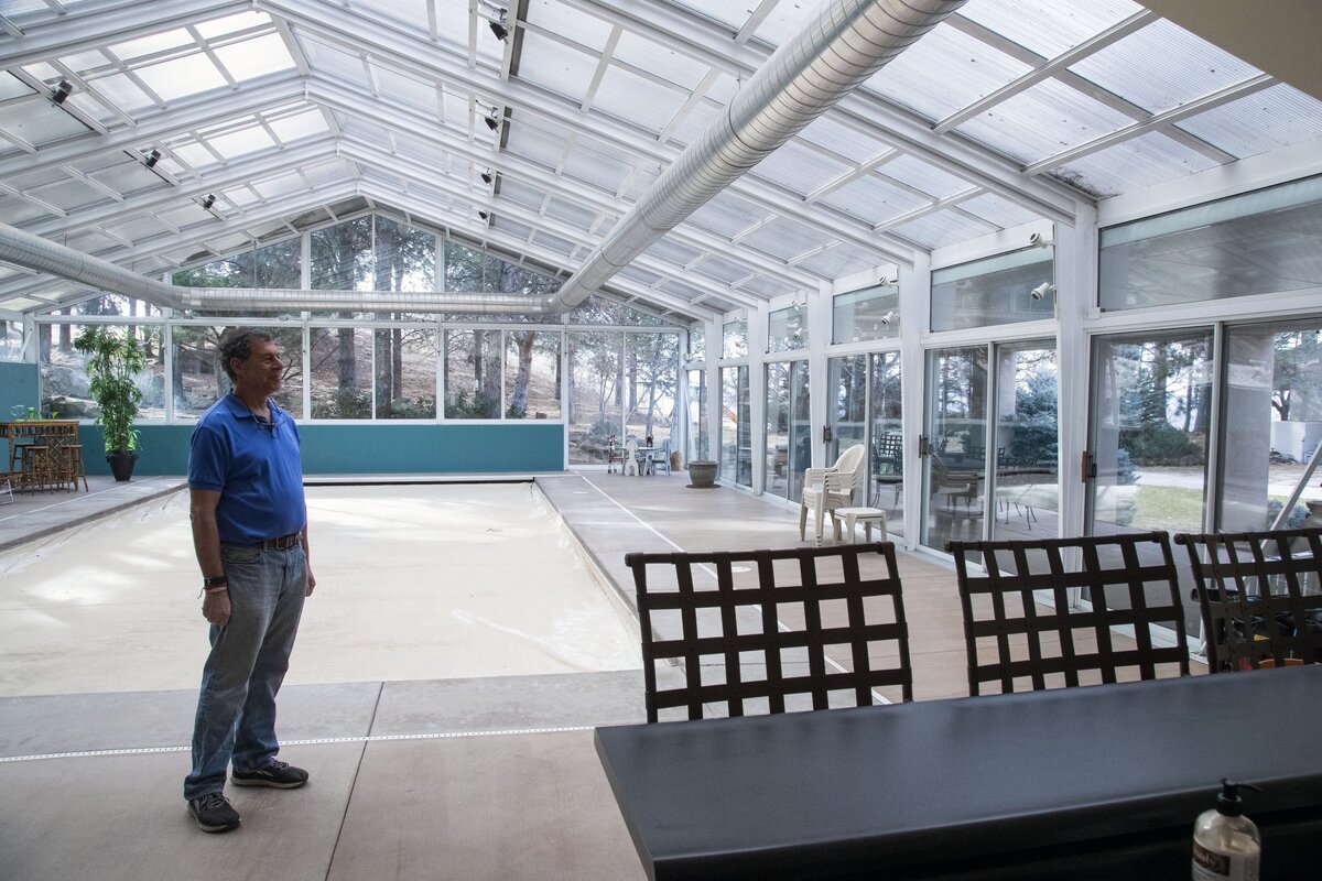 Greg Satz stands in the indoor pool facility his family has enjoyed for decades. The structure is well-vented and includes a small kitchen and sliding doors to a patio area for barbecues.