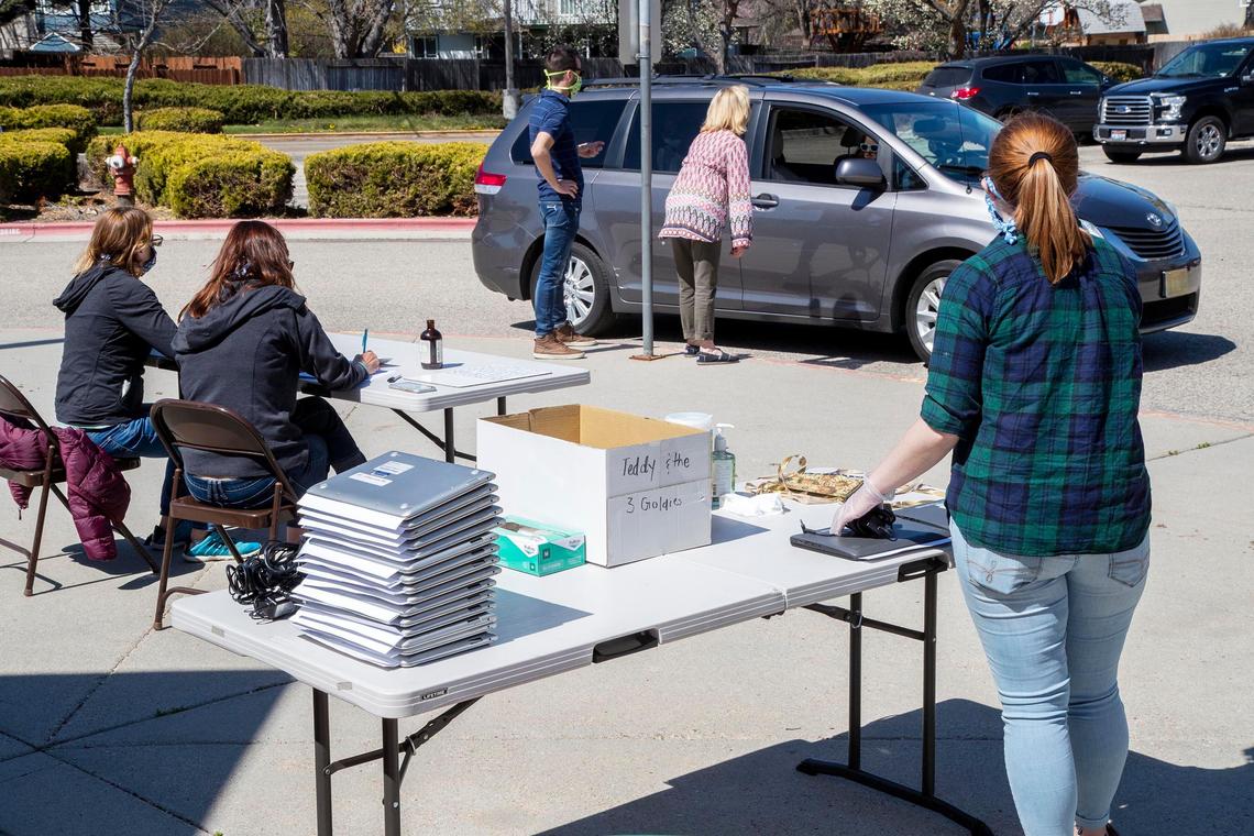 Faculty at Riverside Elementary in East Boise distribute student Chromebooks to parents who received the devices at a drive-up line outside the school April 8. The Boise School District distributed 8,000 laptops to students who needed them.