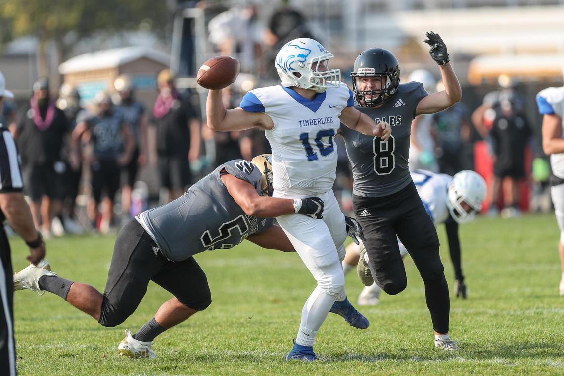 Capital defensive lineman Charley Hastriter, left, tries to bring down Timberline quarterback Max Spielman on Friday, Oct. 9, 2020 at Capital High School.