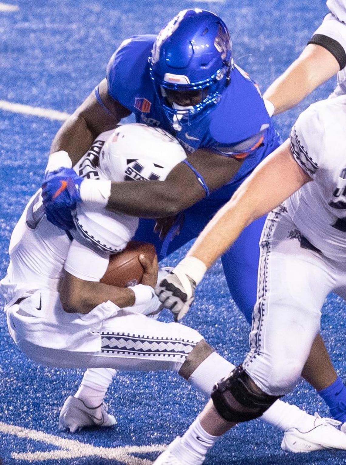 Boise State nose tackle Divine Obichere (95) sacks Utah State quarterback Jason Shelley (15) during the Broncos’ season opener at Albertsons Stadium.