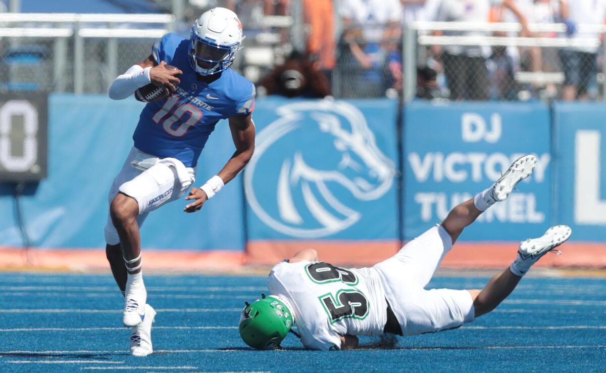 Boise State quarterback Taylen Green escapes a tackle attempt by North Dakota linebacker Wyatt Pedigo. Green had big runs of 21 and 14 yards on scrambles Saturday.
