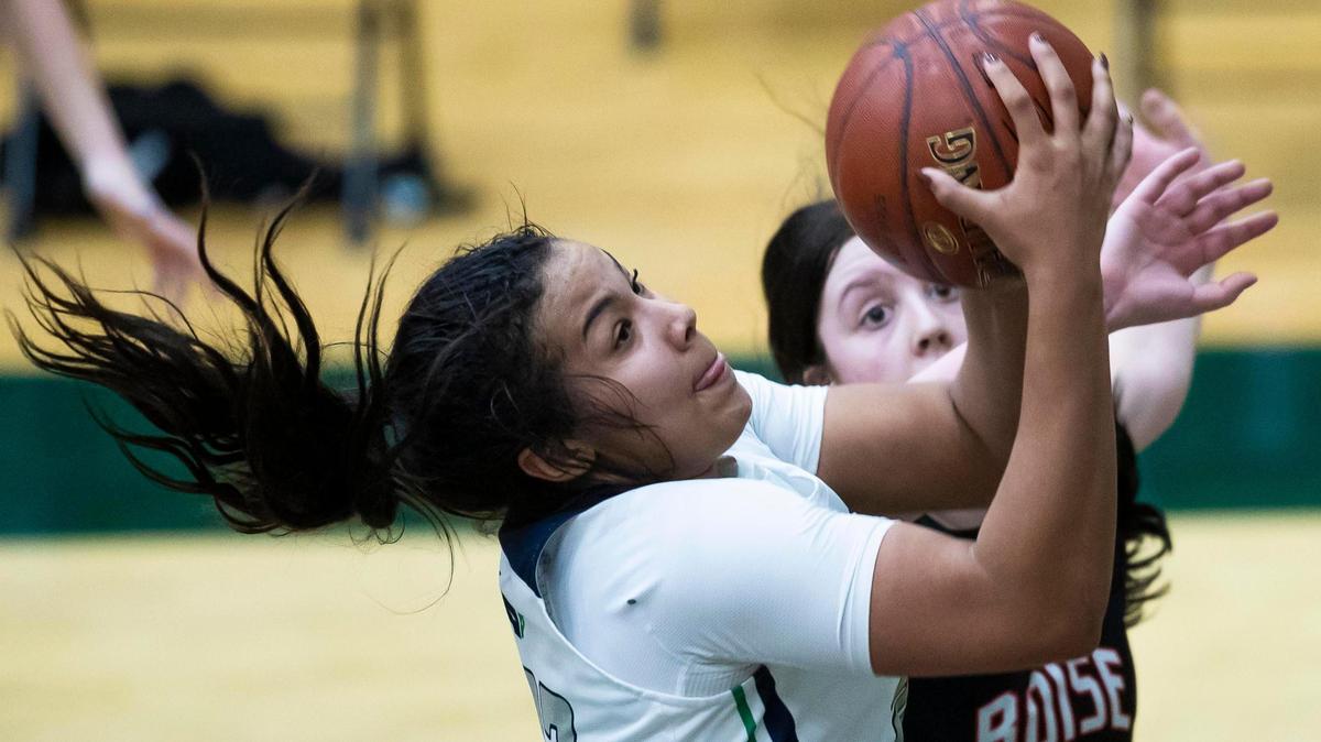 Mountain View junior Naya Ojukwu scores on an offensive rebound while defended by Boise’s Ashley Banks in the 5A District Three Tournament championship Friday at Eagle High School. Mountain View beat Boise 54-47 to win its third straight district title.